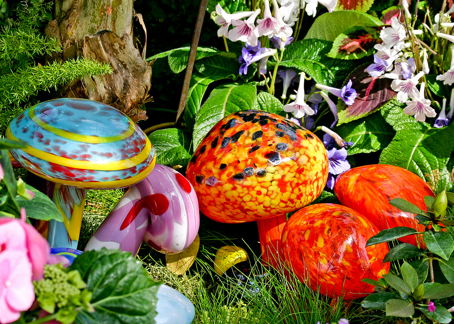 Hand blown multicolored glass mushrooms in garden